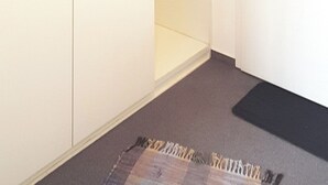 Een kamer met een inbouwkast, een deur met greep en een vloerkleed.