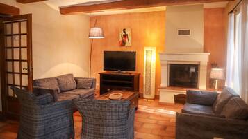 Una sala de estar acogedora con chimenea, televisor y asientos cómodos.