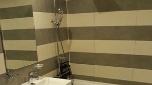 A bathroom with a white sink, a toilet, and a bathtub.