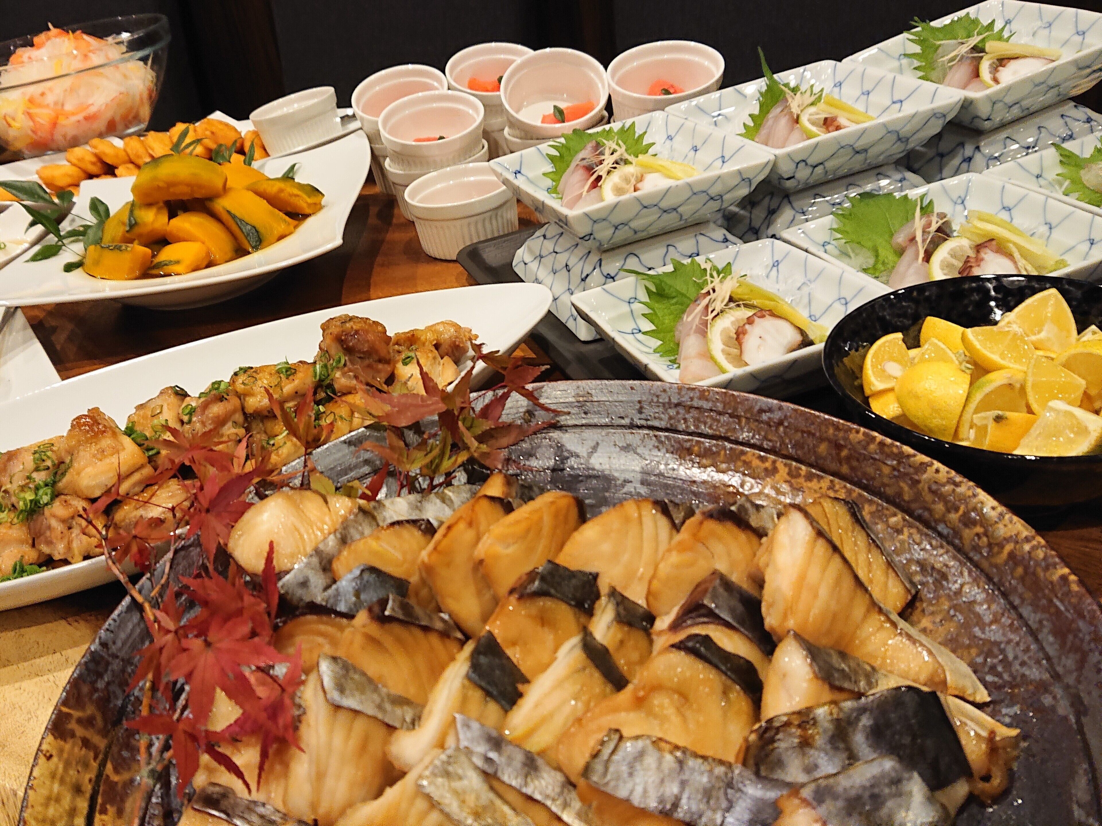 A variety of dishes including seafood, vegetables, and possibly some meat, arranged on a table.