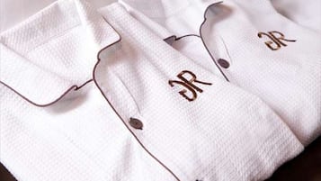 Una camisa blanca con un botón y letras bordadas.