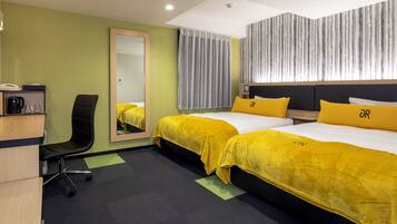 A hotel room with two beds, a desk, a chair, a mirror, and a window with curtains.
