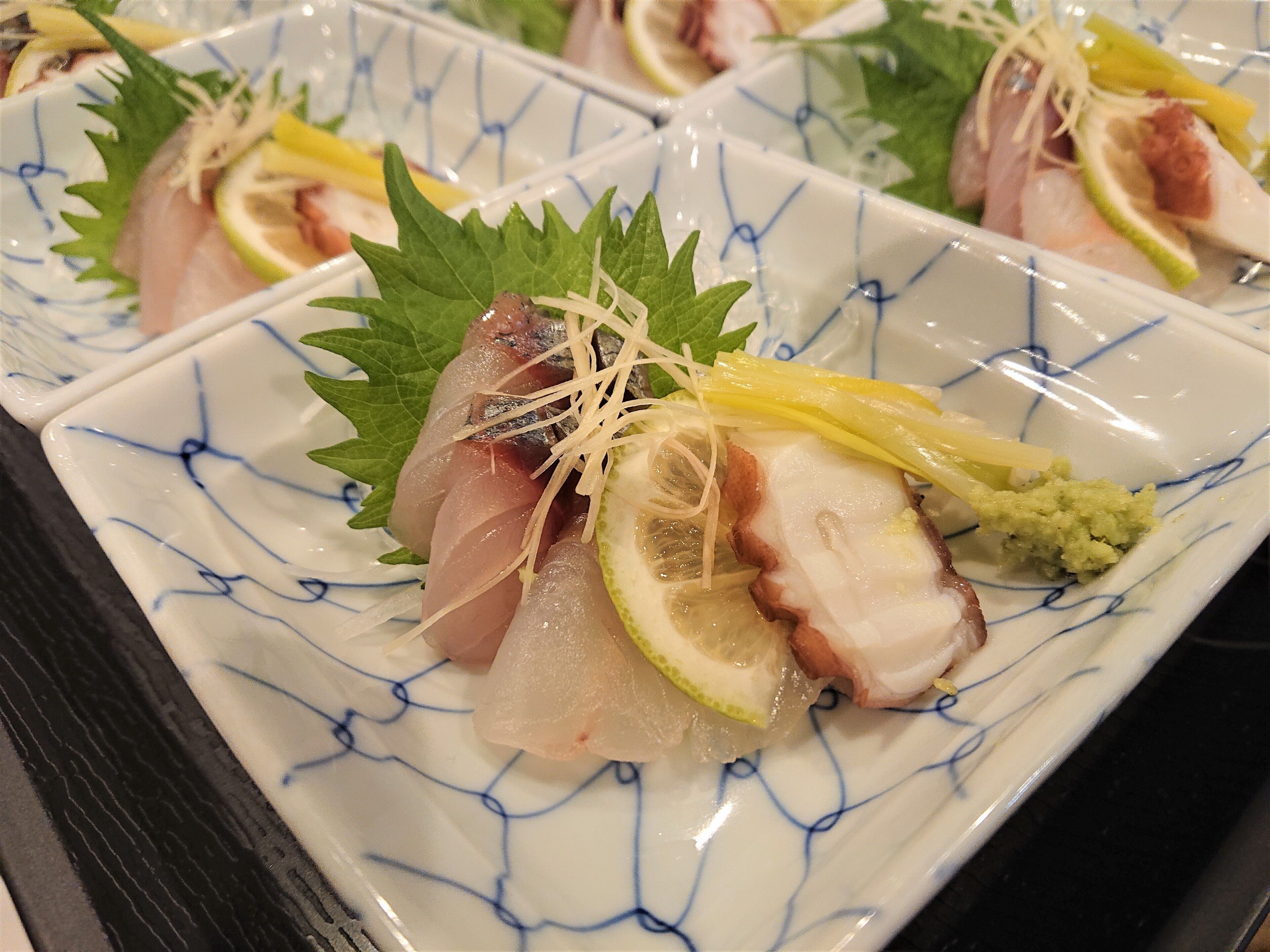 A plate of sashimi with garnishes.