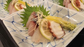 A plate of sashimi with garnishes.