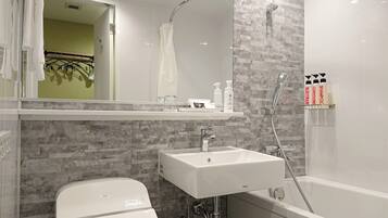 A modern bathroom with a white sink, a bathtub, and a shower. There are toiletries on the sink and a towel rack.