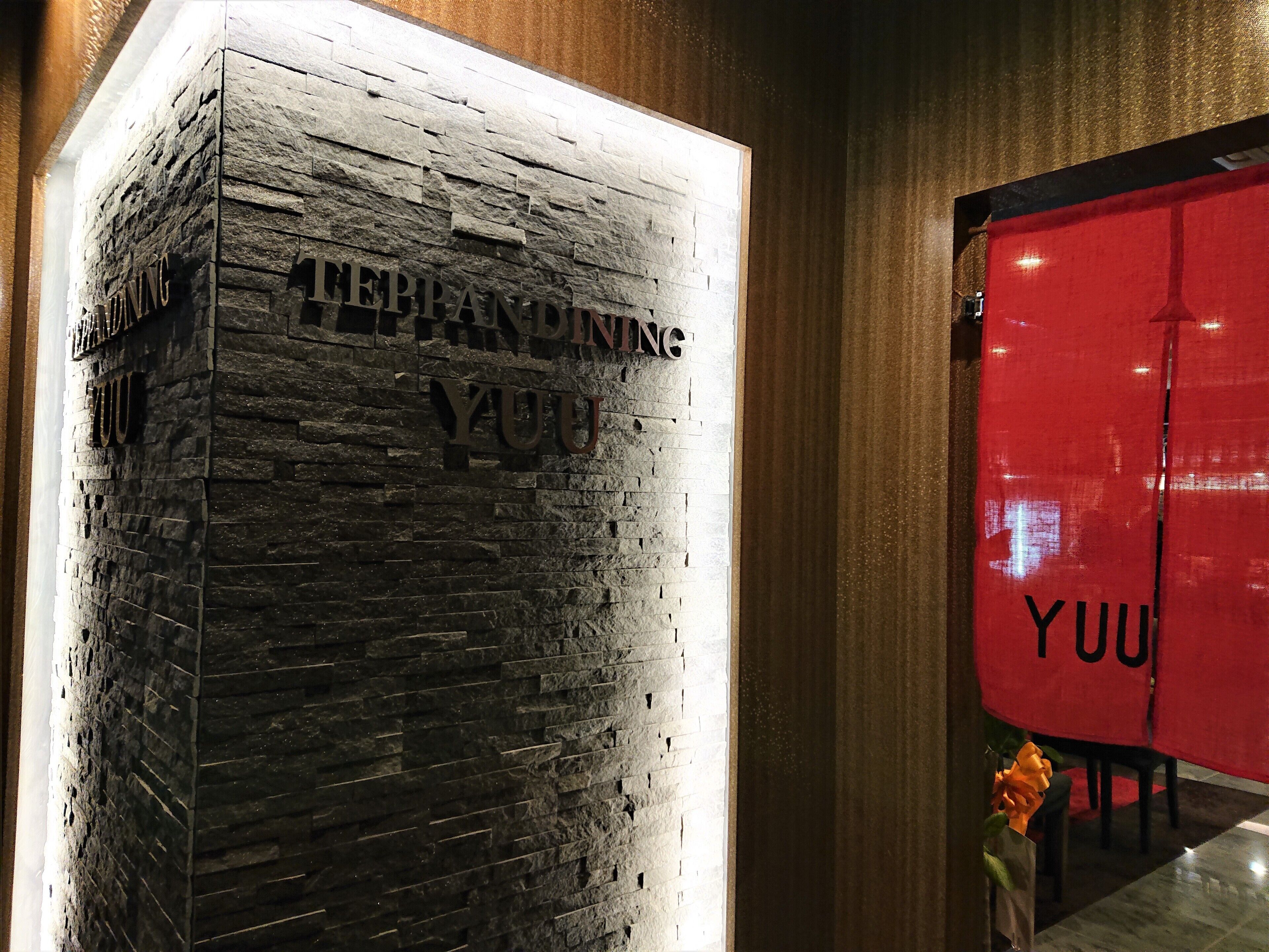 A stone wall with the text "TEPPANDING YUU" and a red structure with "YUU" on it.