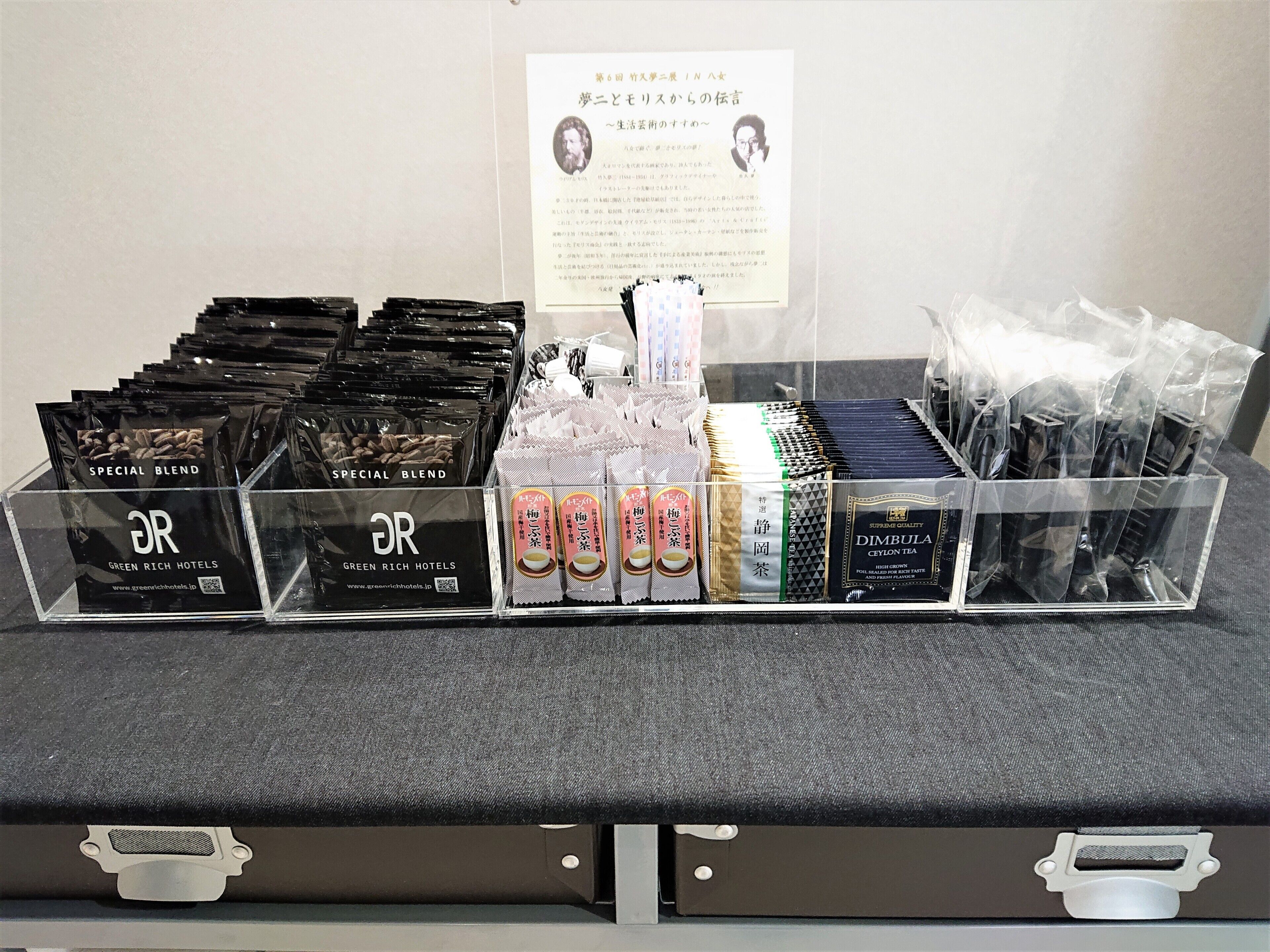 Una exhibición de productos de té, incluyendo té 'Special Blend' y 'Dimbula', dispuestos en recipientes de plástico transparente sobre una mesa.