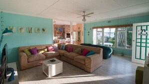 Ein gemütliches Wohnzimmer mit einer Eckcouch, einem kleinen Couchtisch und einem Deckenventilator.