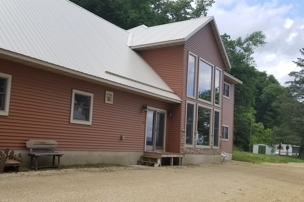 Shared patio area with firepit, gazebo lined with mosquito netting and chairs