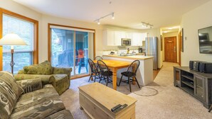 A modern living room with a sofa, a coffee table, and a TV stand. - Aspens #327 Prime Ski-in Ski-out Location! Pool, Hot tubs, Sleeps 8 (Whistler)