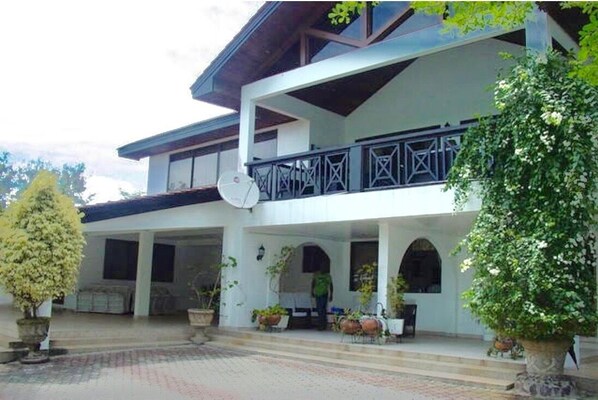 Stunning two-story building with a balcony and arches leading to a covered entrance.