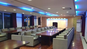 A conference room with a long table and multiple chairs, equipped with ceiling lights and a sound system. - Mangsang Beach Pension (Gangneung)