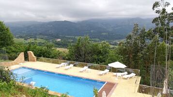 Una piscina al aire libre, tumbonas