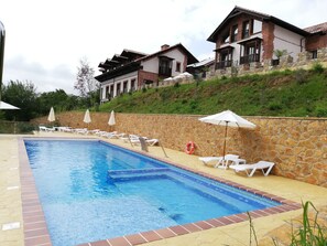 Alberca al aire libre y camastros