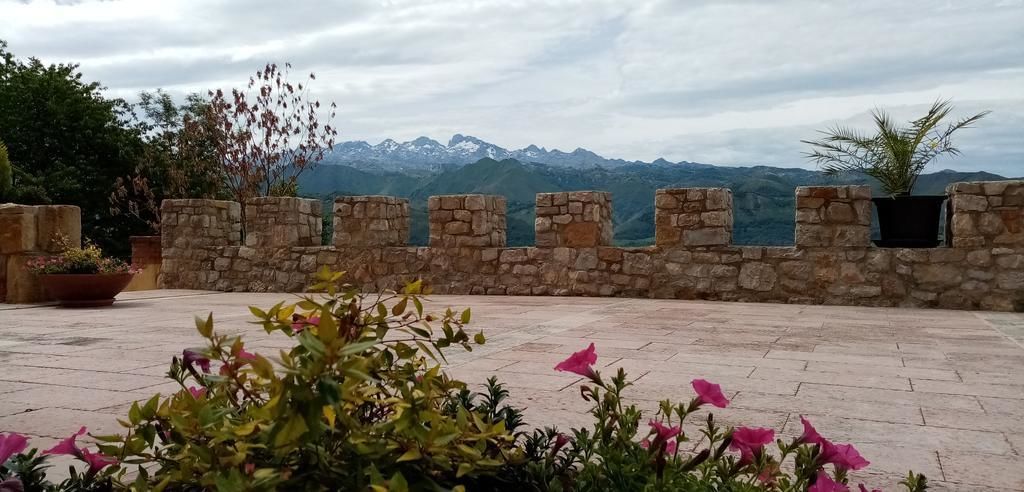 A stone wall with a view of mountains in the background.
