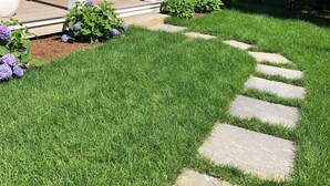A house with a covered porch, a stone pathway, and a well-maintained lawn. - Modern 5 Bedroom Home. Newly constructed. Large yard. Close to beaches and town. (Nantucket)