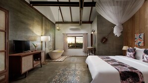 Quarto com cama grande, televisão, banheira e janela com cortinas.