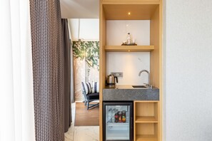A compact kitchen with a refrigerator, a sink, and a coffee maker on a shelf. - Stayso The House Hotel (Istanbul)