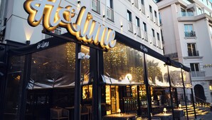 A restaurant with outdoor seating, a prominent illuminated sign, and a view of the street. - Stayso The House Hotel (Istanbul)