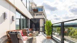 A modern outdoor seating area with a mix of sofas and chairs, a small table, and a potted plant. - Stayso The House Hotel (Istanbul)