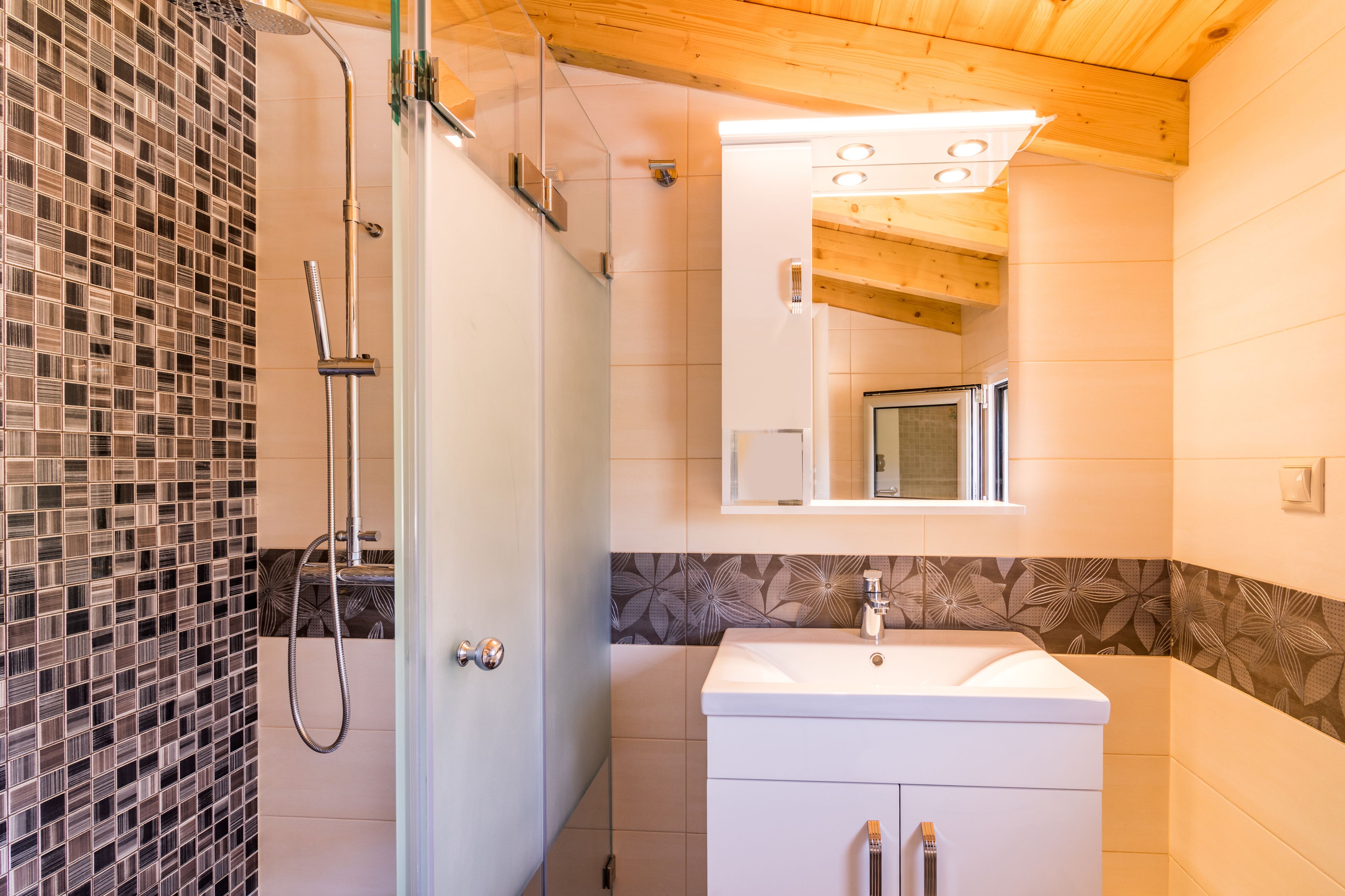 A bathroom with a shower, a sink, and a mirror.