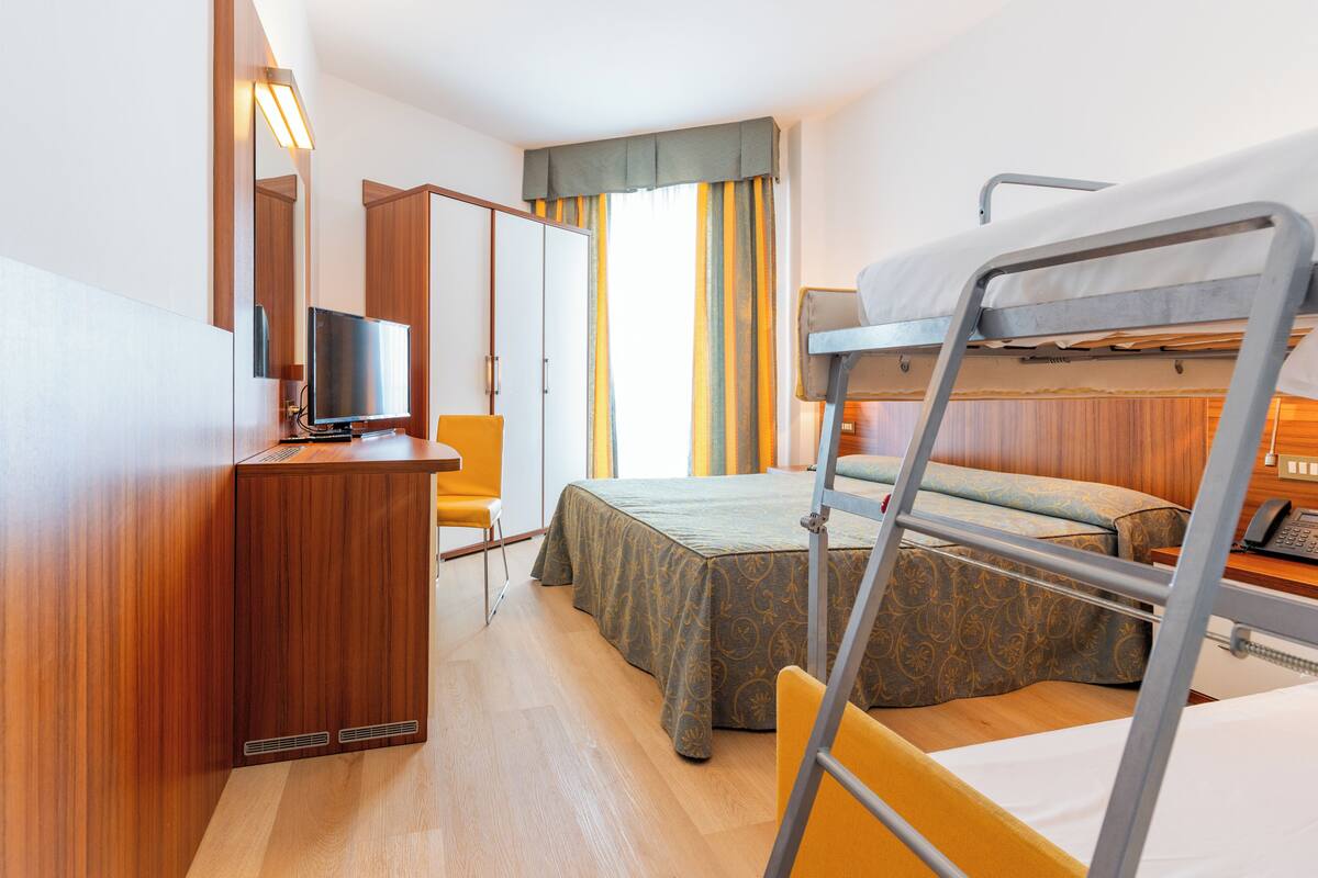 Habitación cuádruple familiar | Escritorio, cunas (de pago), ropa de cama