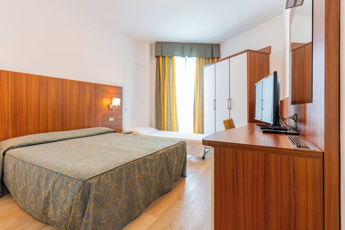 Habitación triple familiar | Escritorio, cunas (de pago), ropa de cama