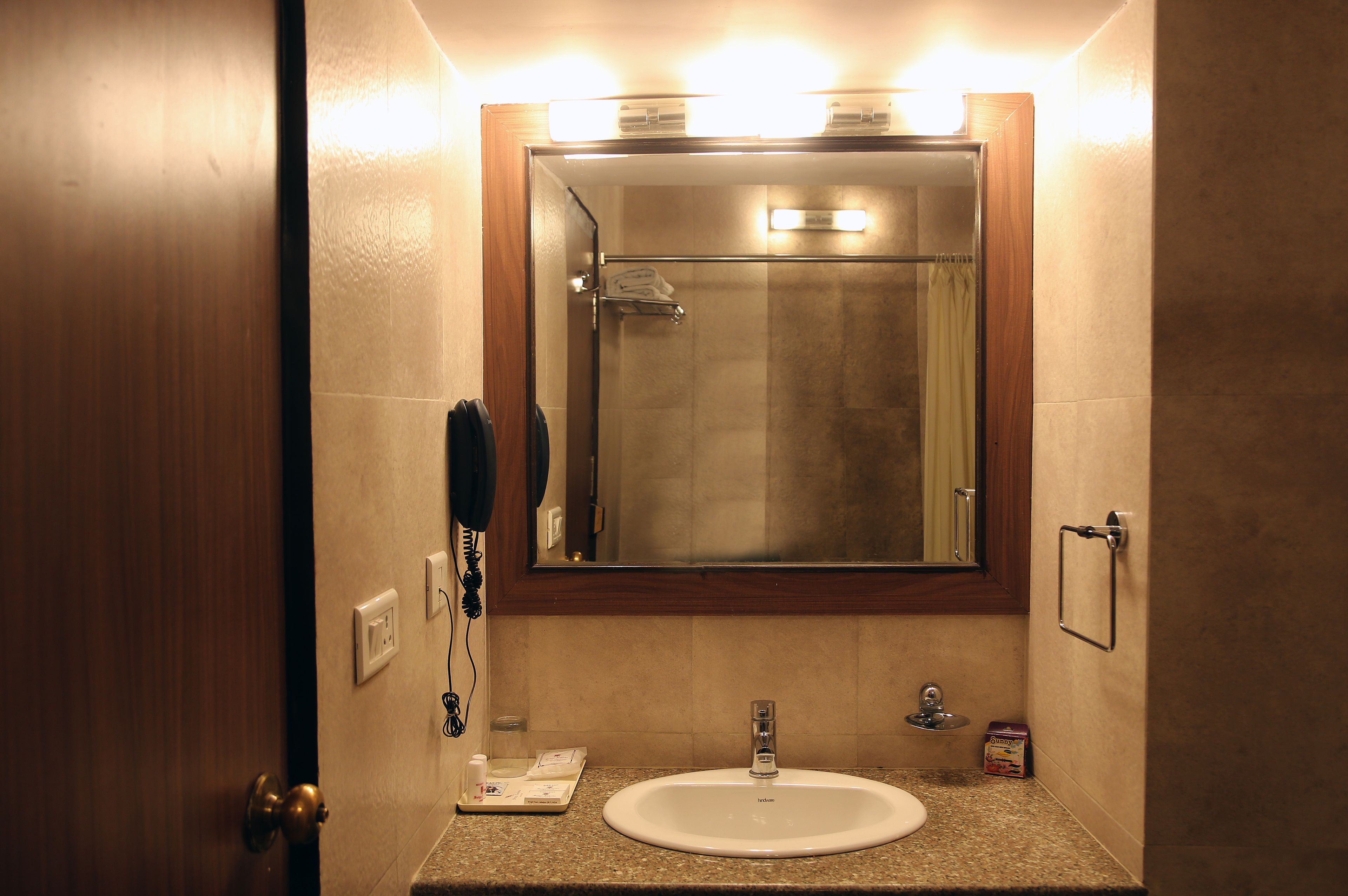 A bathroom with a sink, mirror, and shower.