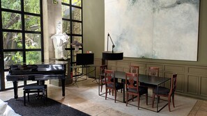 A room with a piano, a dining table with chairs, a large abstract painting, and a sculpture. - Le Complot - Maison Privée à Avignon (Avignon)