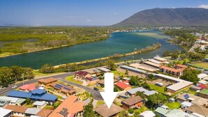 Une ville côtière avec une rivière, des maisons et une montagne en arri ère-plan.