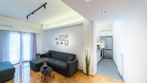 A modern living room with a sofa, a coffee table, and a dining area with a refrigerator.