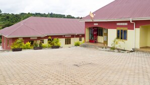 A building with a red roof and yellow walls, featuring a Coca-Cola sign and a Coca-Cola Goodwill logo. - Hoima Breeze Hotel (Hoima)