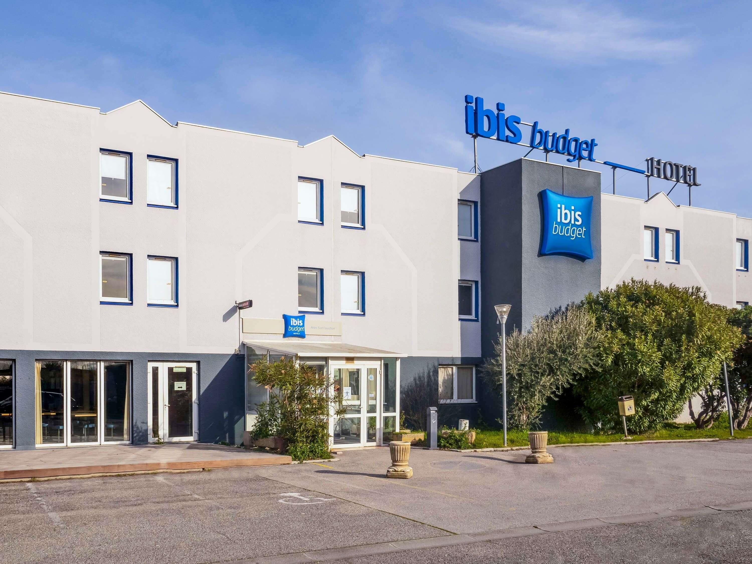 A modern building with a sign reading 'ibis budget hotel'.