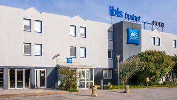 A modern building with a sign reading 'ibis budget hotel'.
