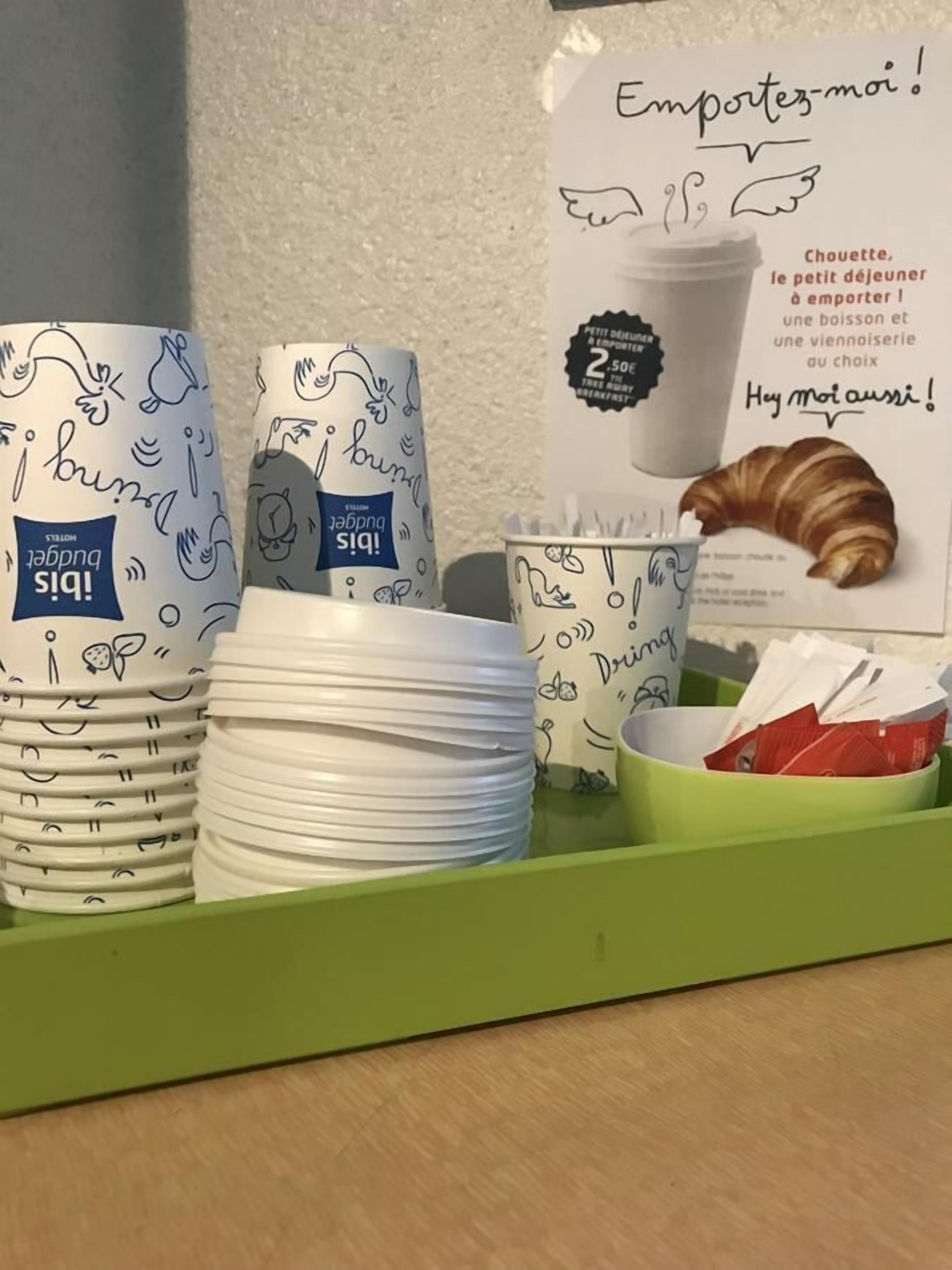 Una bandeja de desayuno con platos, tazas y un croissant.