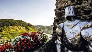 A knight statue next to a stone wall with a flower arrangement.