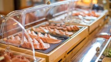 Ein Buffet mit verschiedenen Speisen, die in durchsichtigen Kunststoffbehältern präsentiert werden.