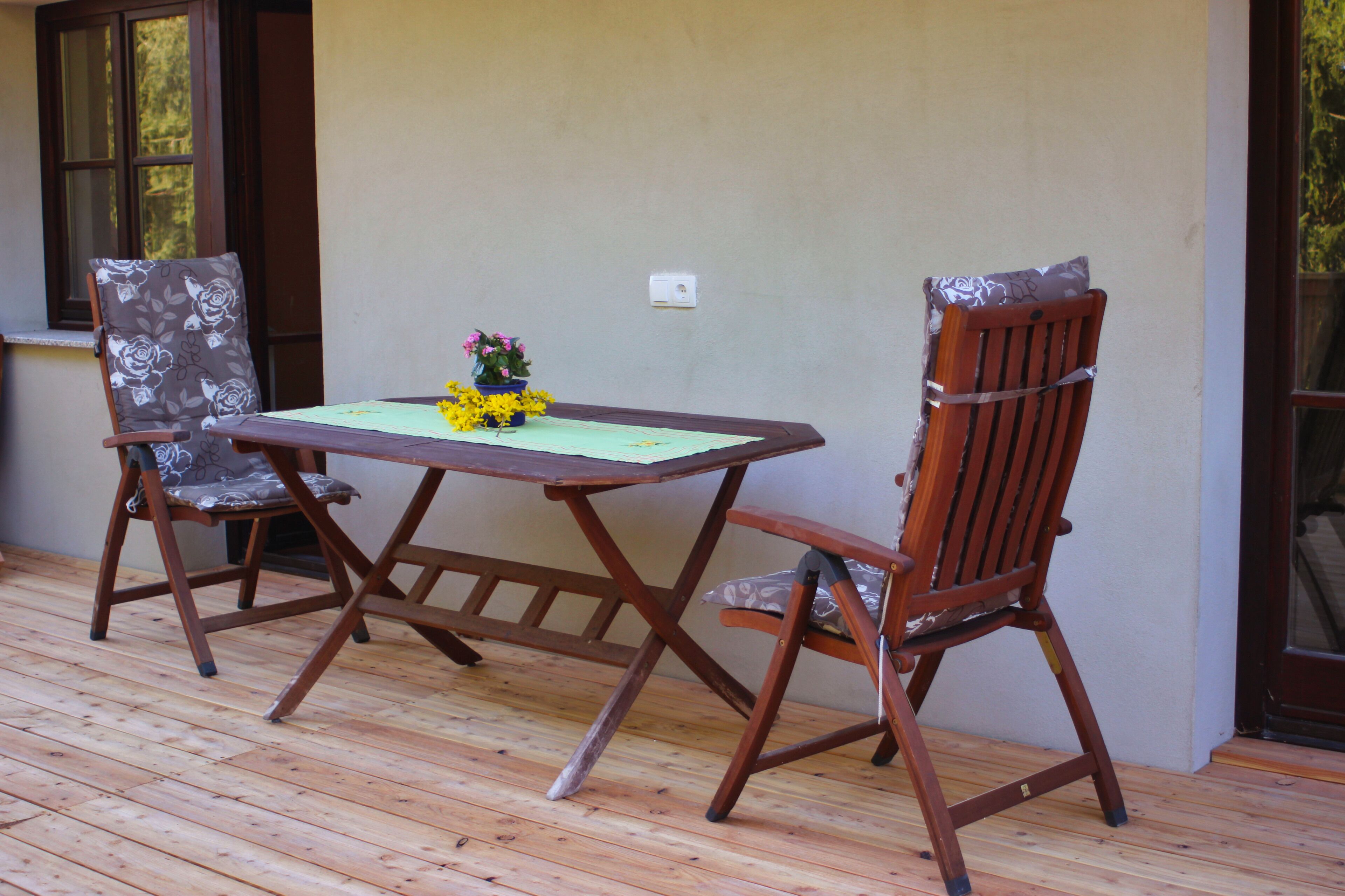 A wooden deck with a table and two chairs.