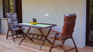 A wooden deck with a table and two chairs.