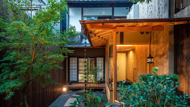 A traditional Japanese house with a wooden exterior, a wooden porch, and a stone pathway leading to the entrance. - KumoMachiya Takoyakushi (Kyoto)