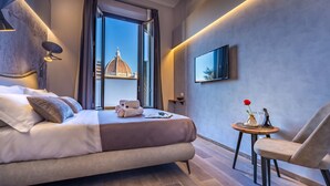 Une chambre d’hôtel moderne avec un grand lit, une petite table ornée d’un vase et une chaise.