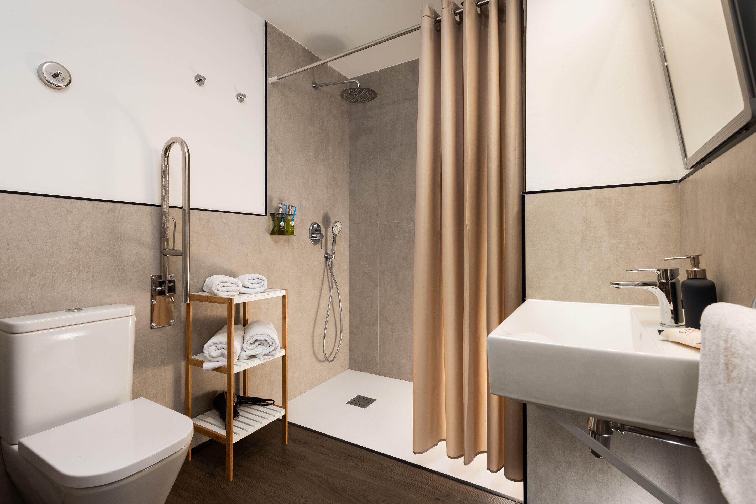 A modern bathroom with a shower, toilet, and sink.