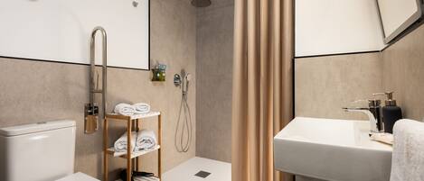 A modern bathroom with a shower, toilet, and sink.