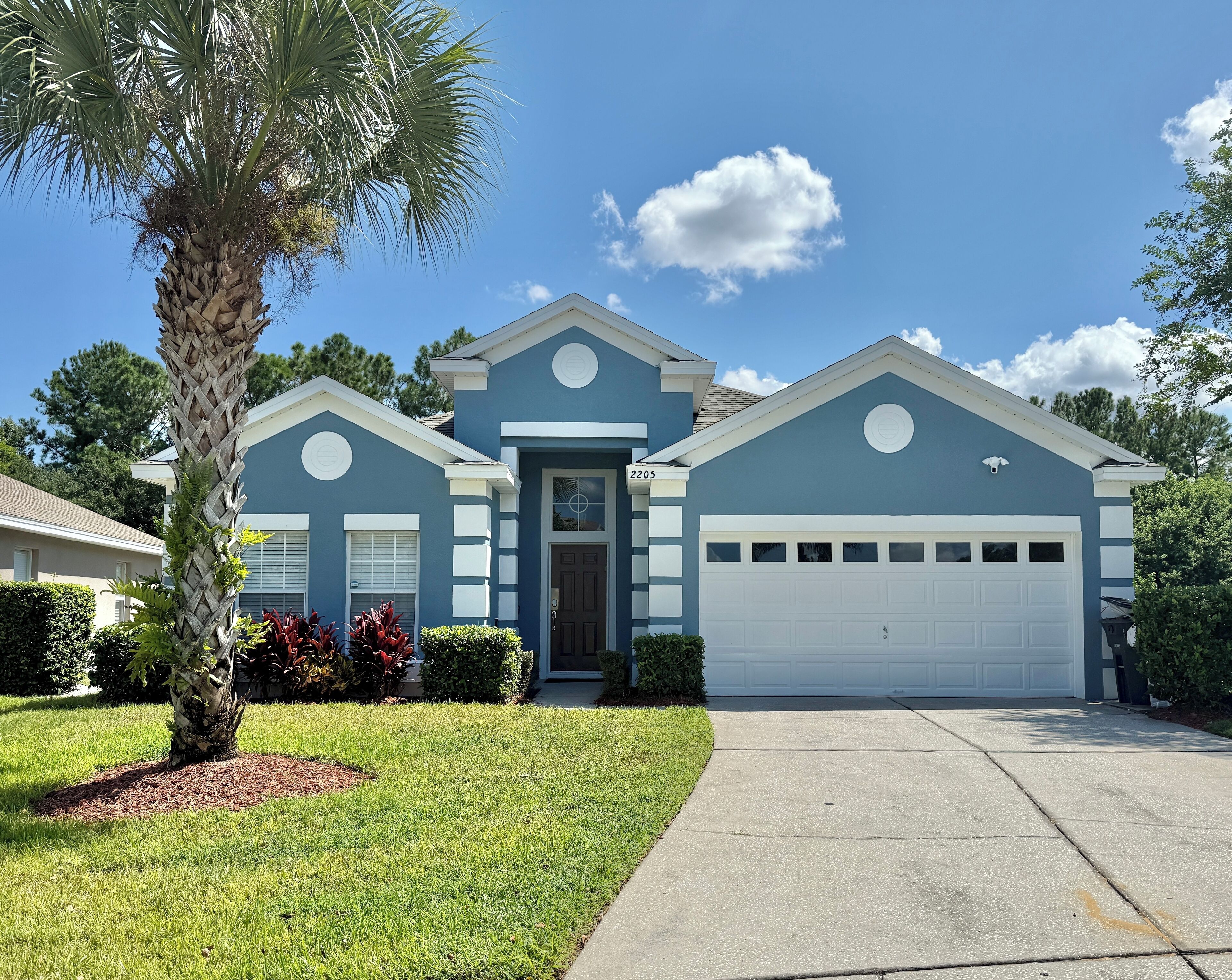 A two-story house with a garage, a front door, and a mailbox.