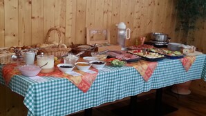 A buffet table with various food items and containers, set against a wooden wall. - Gasthaus Deutscher Jäger (Hornberg)