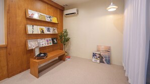 A room with a wooden wall, a bench, a plant, and framed pictures. - La Villa Foret (Busan)