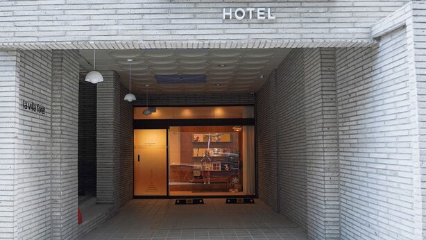The entrance of La Villa Forêt hotel with a modern brick facade and a clear view into the interior. - La Villa Foret (Busan)