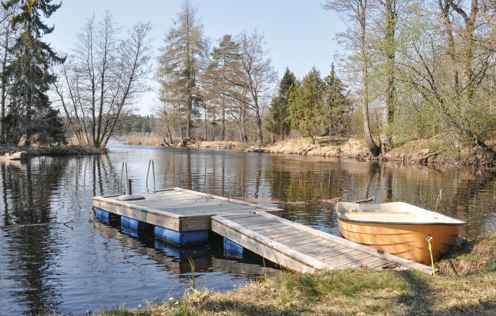 Une jetée en bois s’étendant dans une rivière paisible, bordée d’arbres.