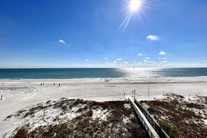 A beach with a wooden boardwalk leading to the shore, clear skies, and the ocean. - Royal Palms 402 1 Bedroom Condo by RedAwning (Gulf Shores)