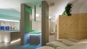 A spa area with a reception desk, a heated stone bath, and reclining chairs. - Spa Suites Odeon (Naron)